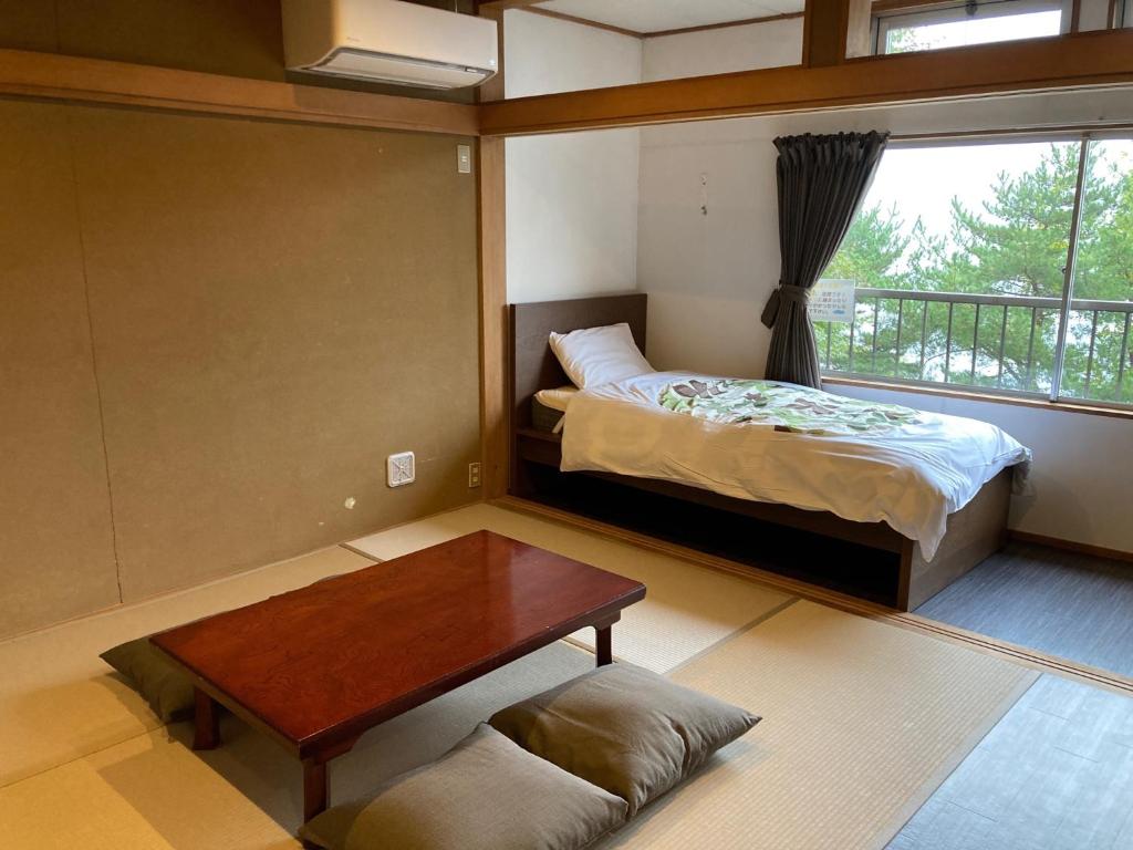 a bedroom with a bed and a table and a window at Koya TRIBE - Vacation STAY 83089v in Oishi