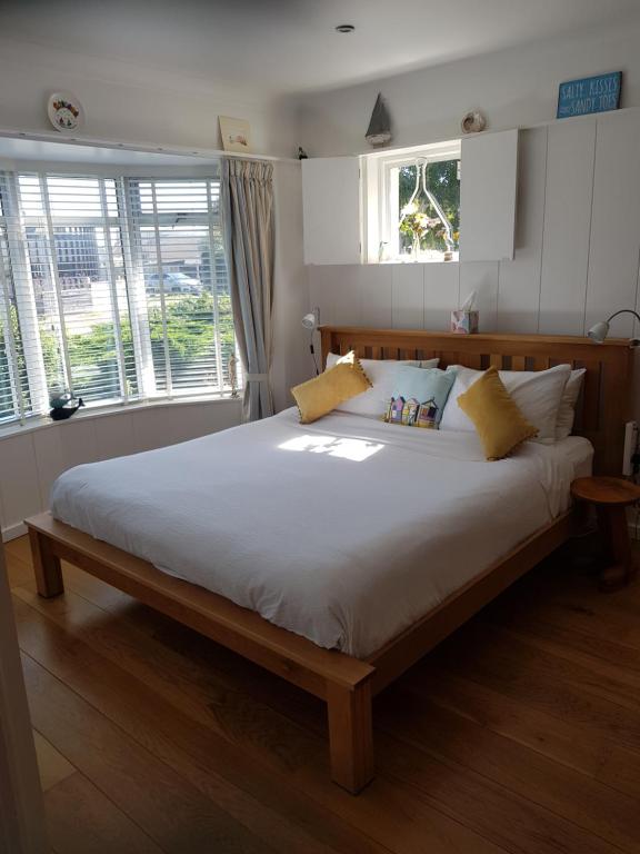 duże łóżko w sypialni z dwoma oknami w obiekcie The Slopes w mieście Whitstable