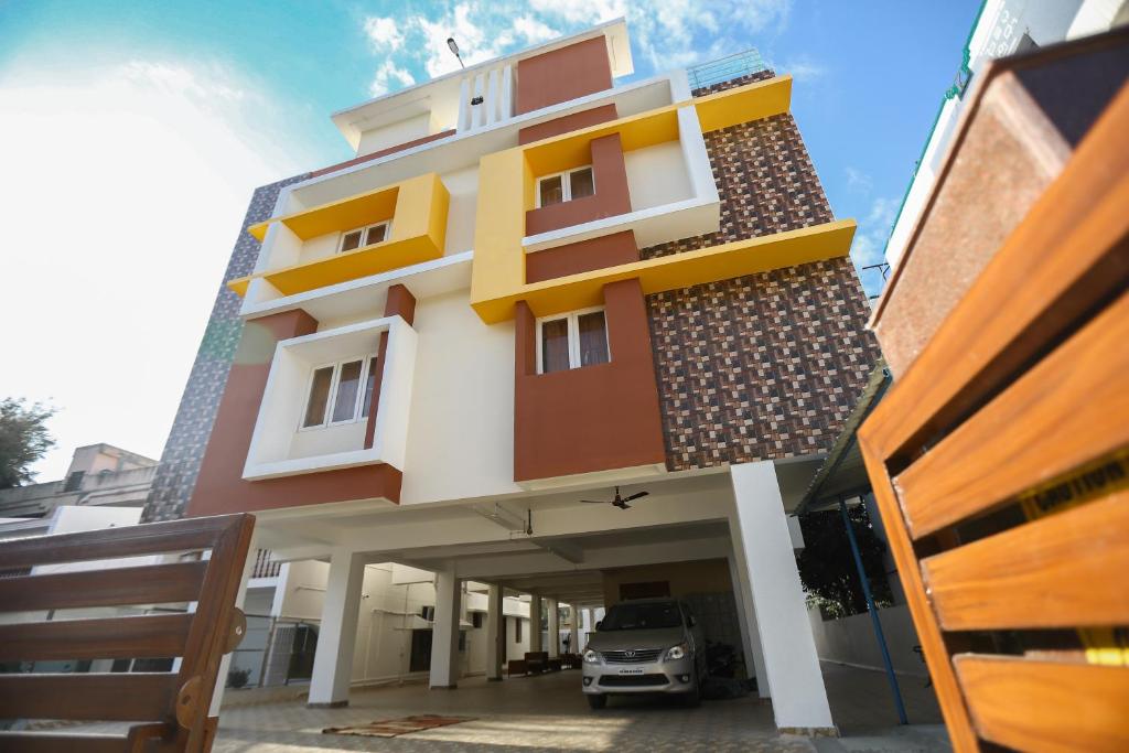 un bâtiment avec une voiture garée devant lui dans l'établissement RAMANA'S HOME STAY Apartment Hotel Kumbakonam, à Thanjavur