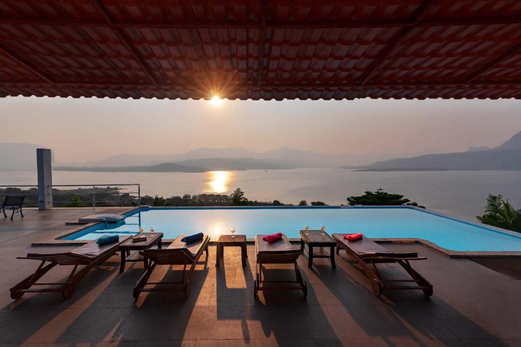une villa avec une piscine, une table et des chaises dans l'établissement StayVista's Princess - A Villa with Infinity Pool & Breathtaking Views, à Lonavala