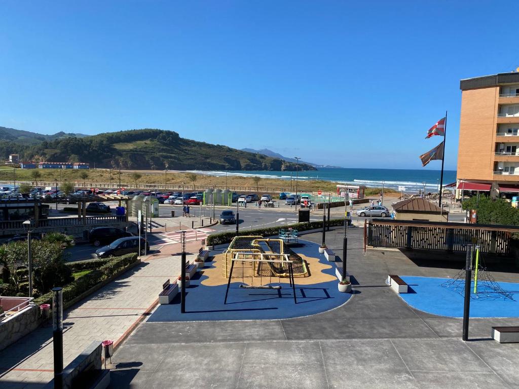 a park with a playground and the beach at La Arena Beach sunset in Ciérvana