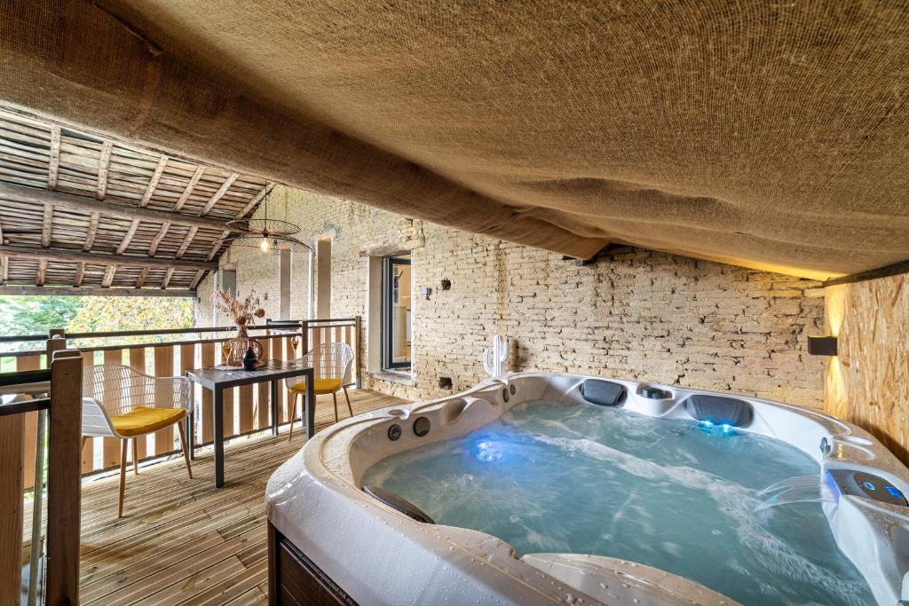 uma grande banheira de hidromassagem num quarto com varanda em Le Cocon & SPA Privé - l'Oliveraie d'Eurocentre em Castelnau-dʼEstrétefonds