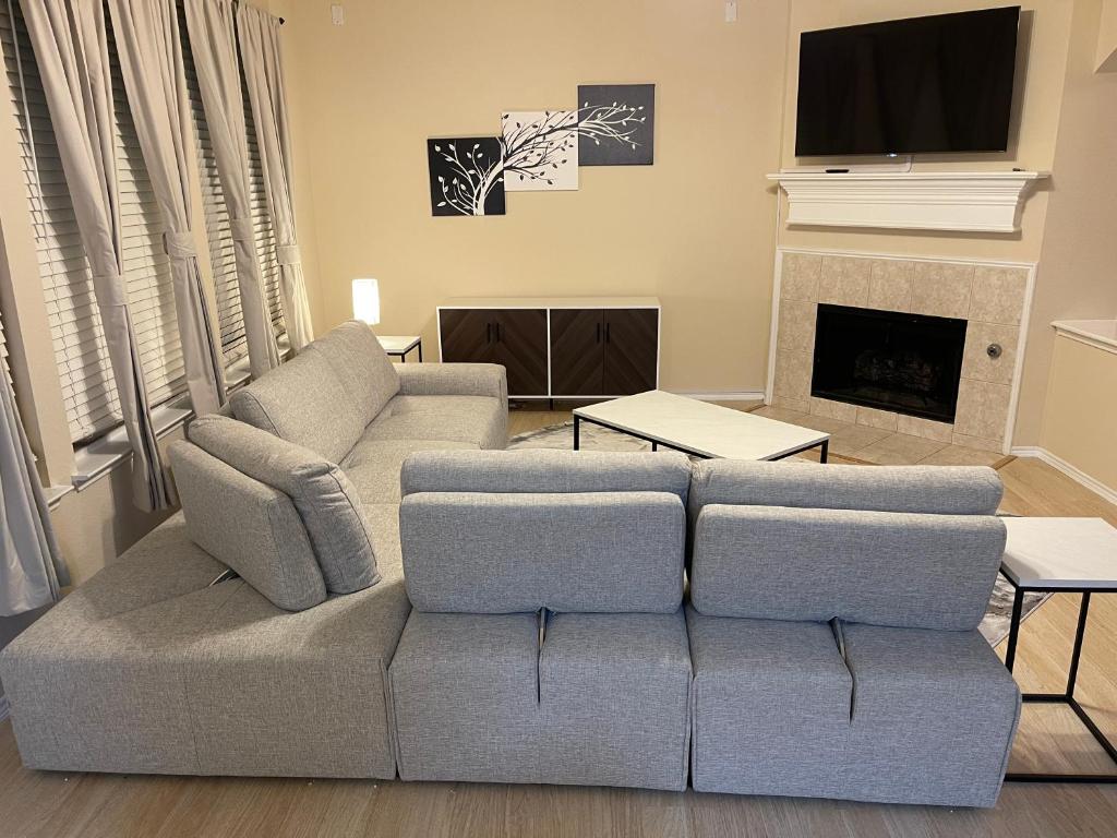 sala de estar con sofá y chimenea en Modern 3BR House - Game Room, Office, Backyard, en The Colony