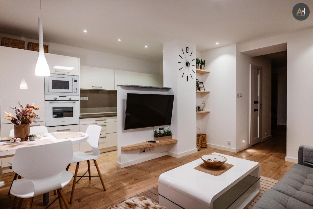 a kitchen and living room with a table and a tv at AH Park Angelinum in Košice