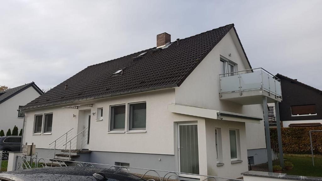ein weißes Haus mit schwarzem Dach in der Unterkunft Joanna Apartment - MA Rheinau 5 in Mannheim