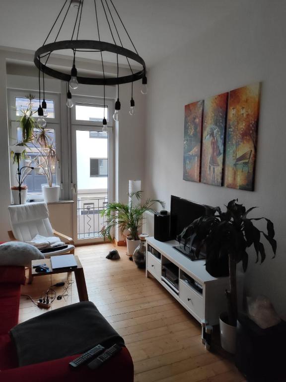 a living room with a couch and a tv and a potted plant at Joanna Apartment - MA Rheinau 4 in Mannheim