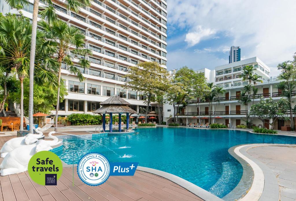 a large swimming pool with a gazebo in front of a building at Cosy Beach Hotel - SHA Extra Plus in Pattaya South