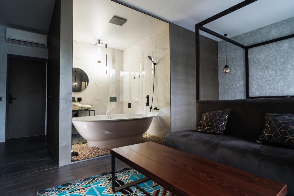 a bathroom with a bath tub and a couch and a bath tub at Sofa Boutique Hotel & SPA in Sumy