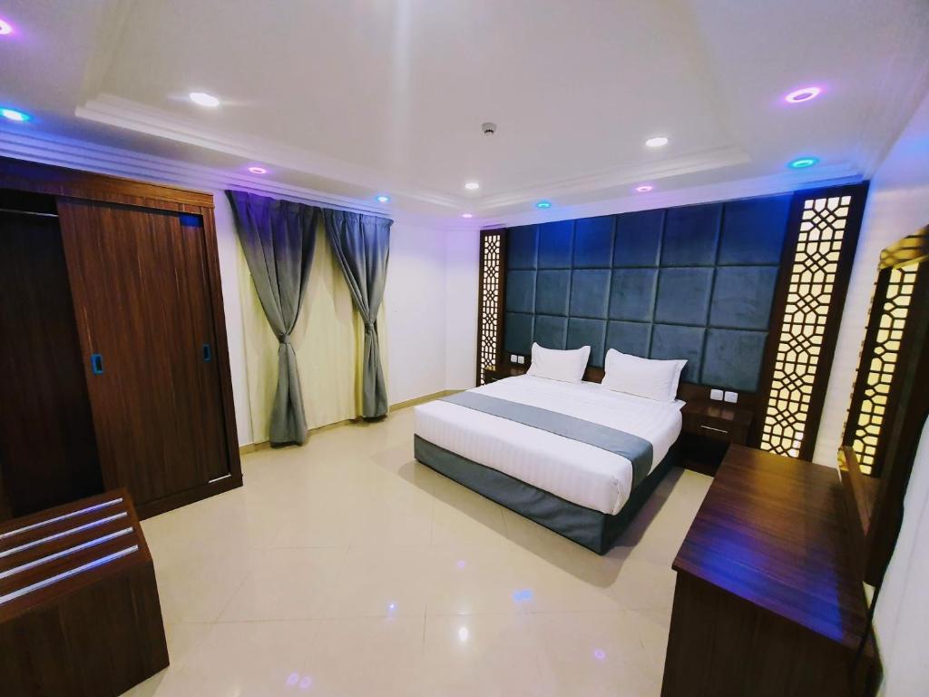 a bedroom with a bed and a desk and a bed sidx sidx sidx at Ahla Taif Apartments in Abha