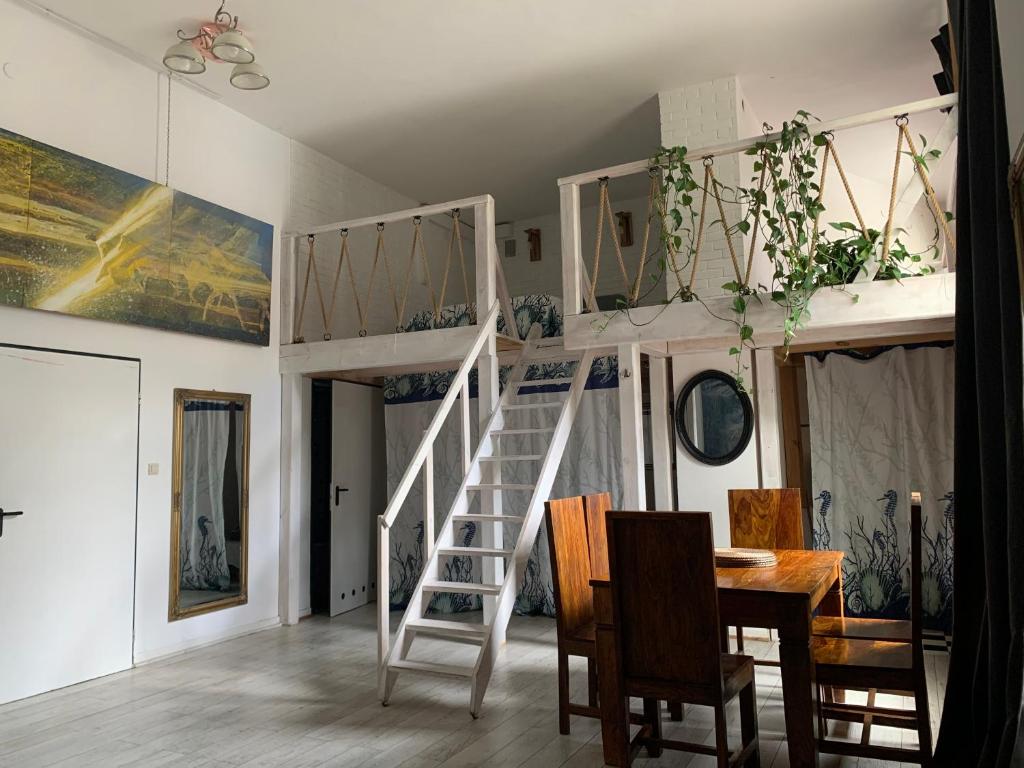 a room with a loft bed and a table and chairs at Art Loft Koszykowa in Warsaw