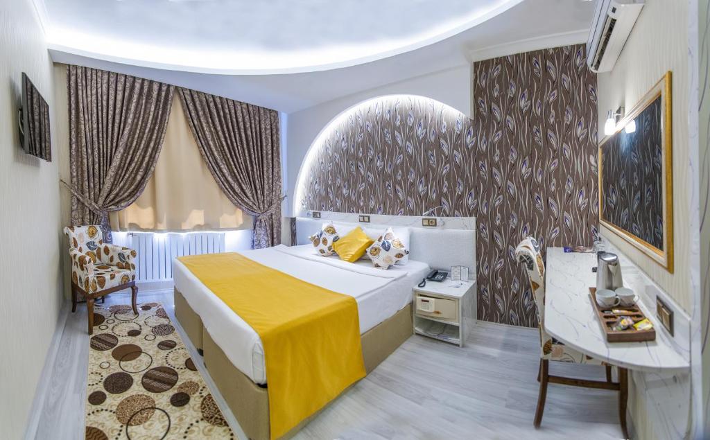 1 dormitorio con 1 cama y 1 mesa en una habitación en Dündar Hotel en Konya