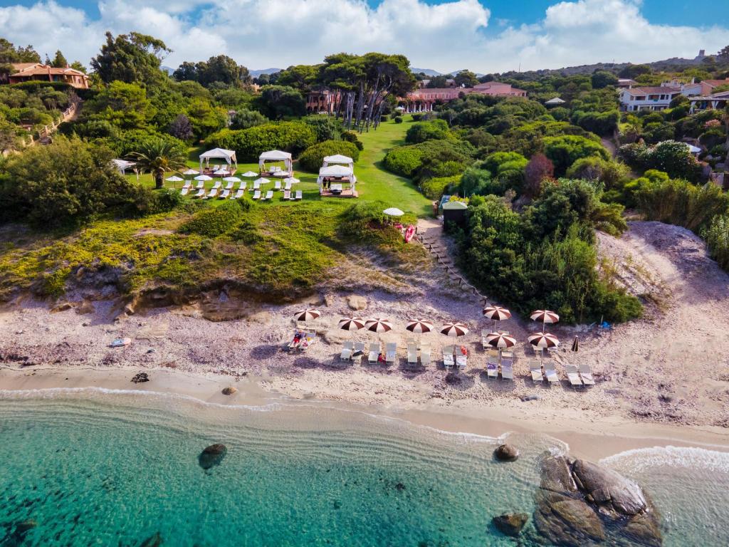 an aerial view of a beach with people and umbrellas at Hotel Cala Caterina in Villasimius