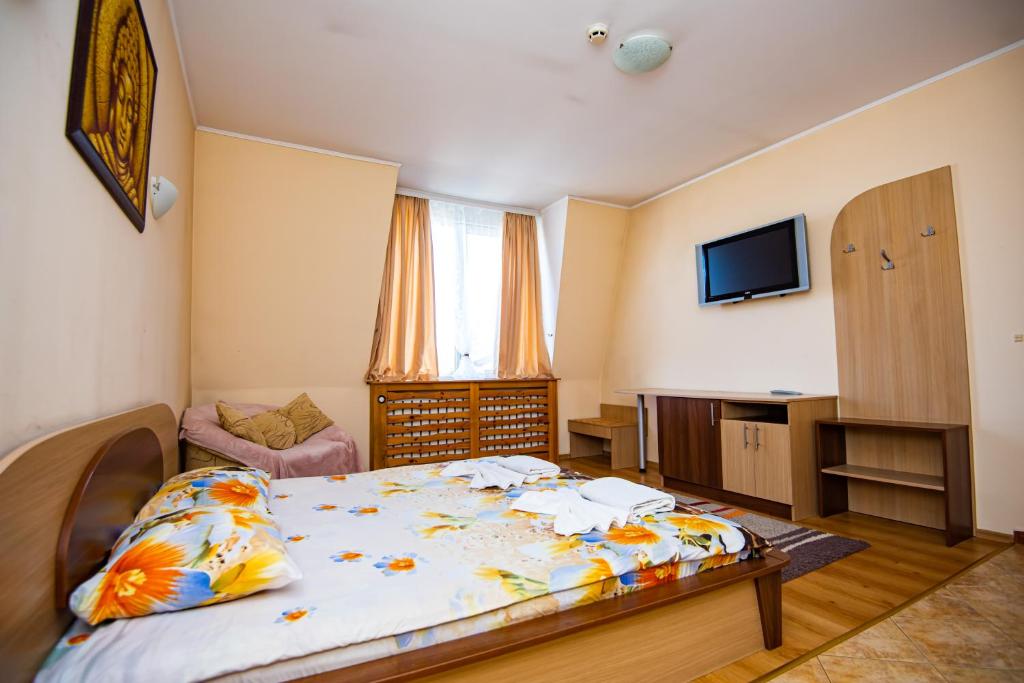 - une petite chambre avec un lit et une télévision dans l'établissement Семеен Хотел Надежда, à Razlog