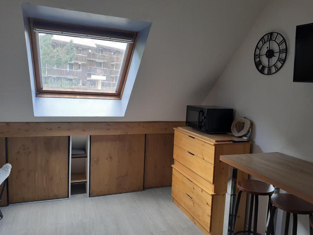 a loft room with a desk and a window at Jolie studio au coeur d'Allos in Allos