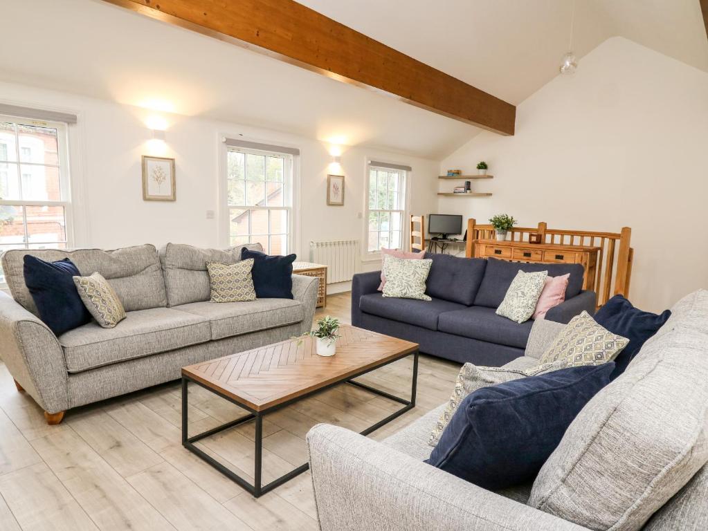 a living room with two couches and a coffee table at Bridgend Cottages in Llandrindod Wells