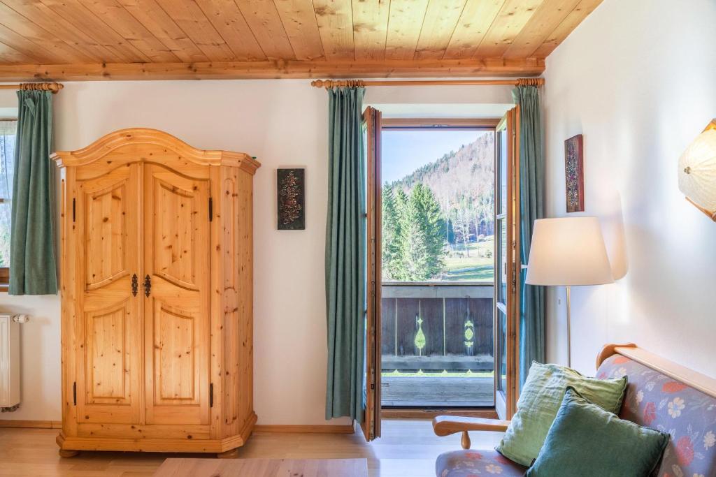 a living room with a wooden door and a window at Ferienwohnung Karwendelblick in Jachenau