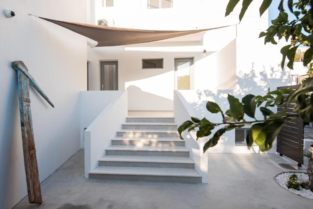 a staircase leading up to a house with white walls at Rivière Residence Paros in Naousa