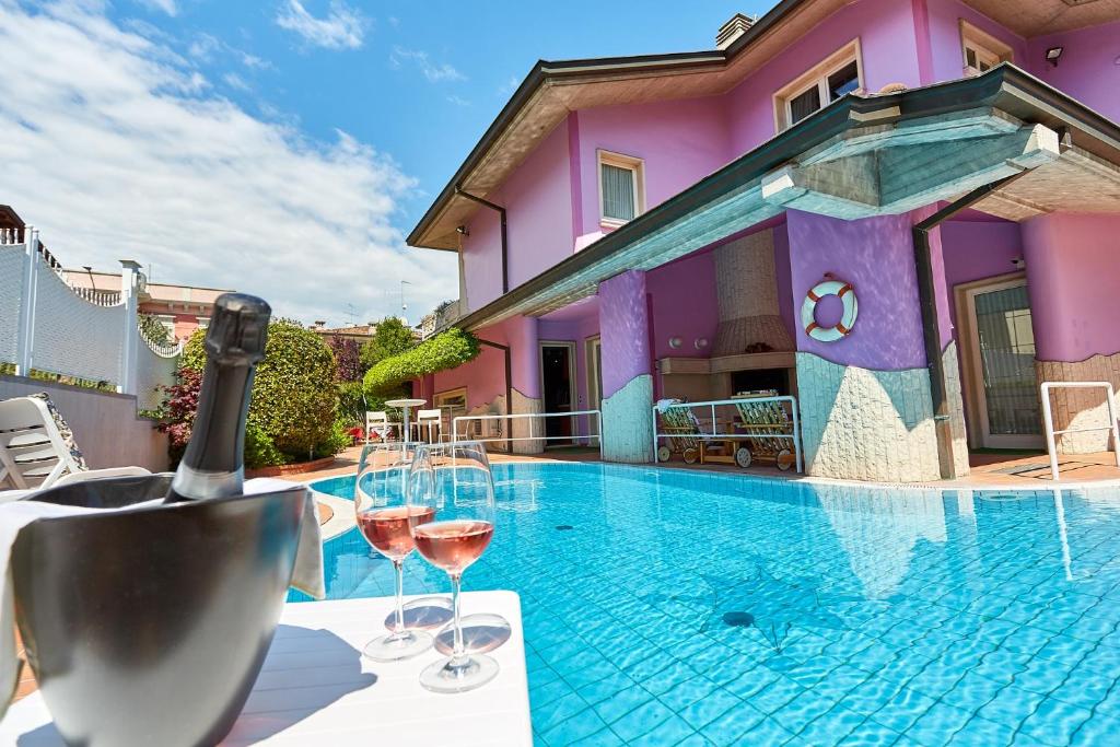 een huis met een zwembad met glazen wijn bij HOTEL Villa Lilla in Desenzano del Garda