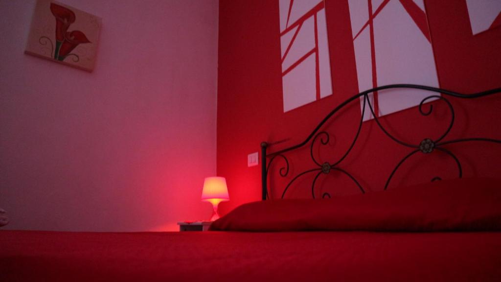 a red bedroom with a bed and a lamp at Villa Bema in Sarno