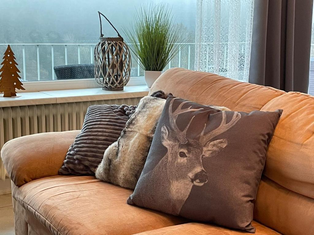 eine Couch mit Kissen mit Hirschkopf drauf in der Unterkunft Bergchalet Heidestock in Willingen