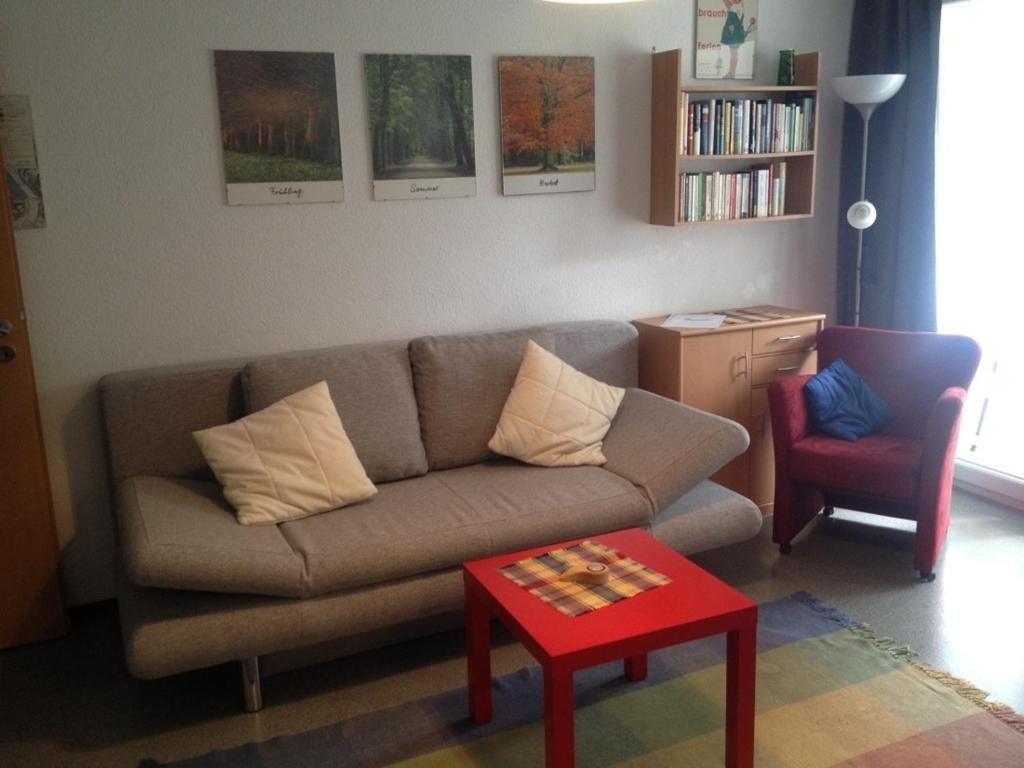 a living room with a couch and a red table at Fewo 91 WHG B 15 in Burhave in Burhave
