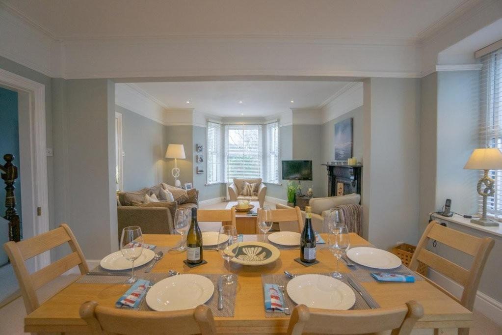 a dining table and chairs in a living room at Mairannedd in Abersoch