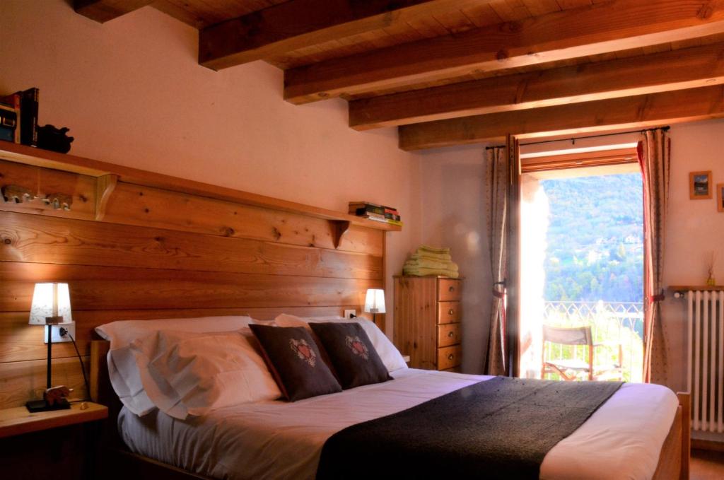 a bedroom with a bed with a wooden wall at La Fattoria di Roven in Gignod