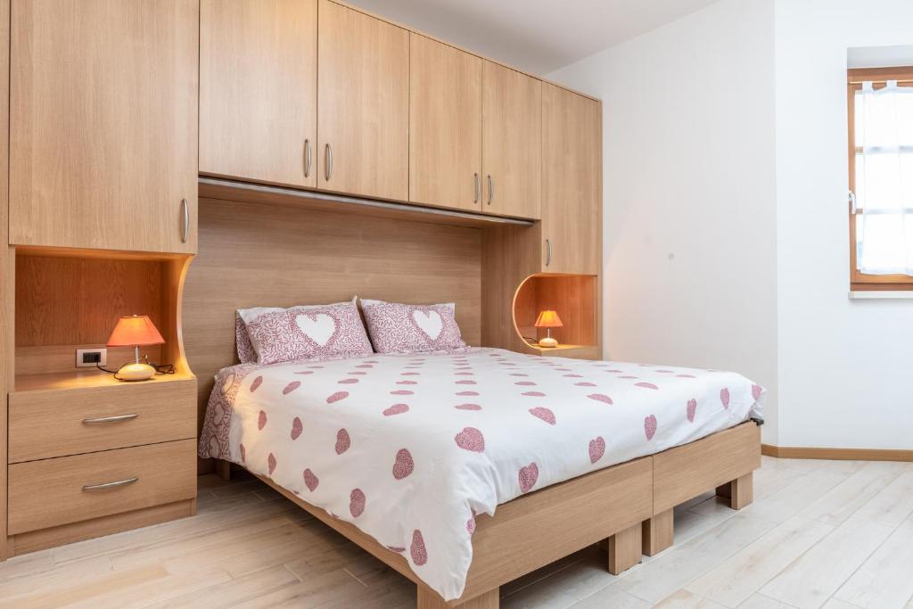 a bedroom with a large bed and wooden cabinets at Dimora La Val in Andalo