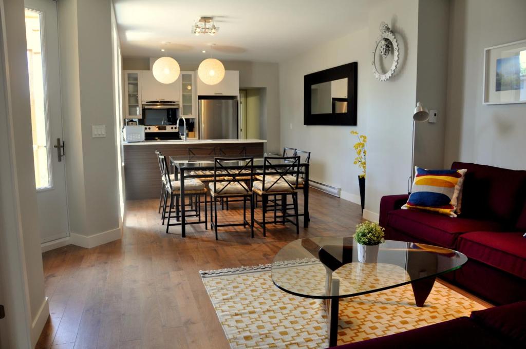 a living room with a red couch and a table at Le Mont-Royal Sky by HomeInMontreal in Montreal