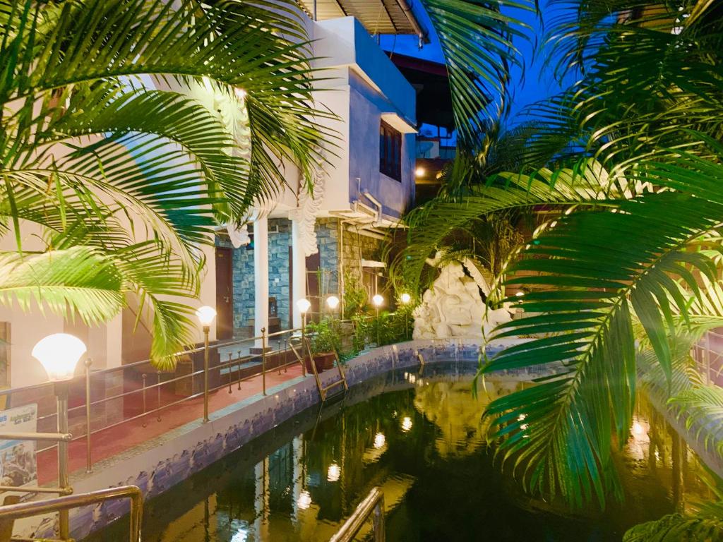 una piscina de agua con palmeras junto a un edificio en Swarajdeep Vacations, en Port Blair