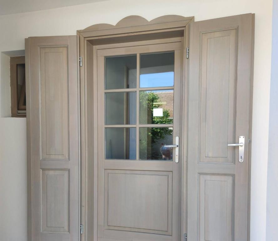 una puerta de madera con una ventana en una casa en Das Blaue Haus Guesthouse - Kovácshida en Kovácshida