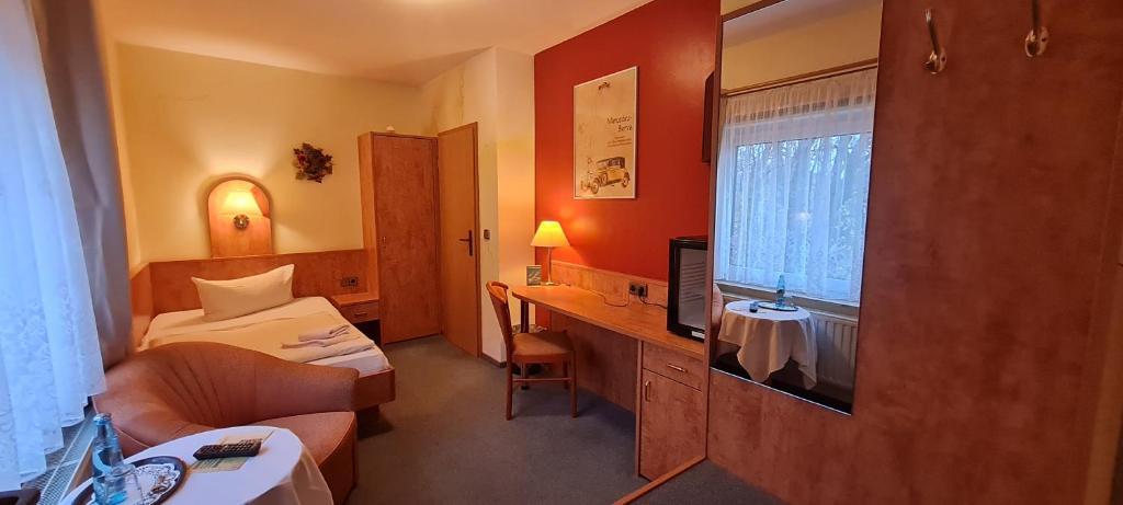 a hotel room with a bedroom with a bed and a desk at Hotel Prox in Arnstadt