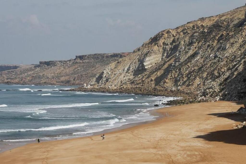 a beach with people walking on the sand at Ait Mouli Surf House in Safi