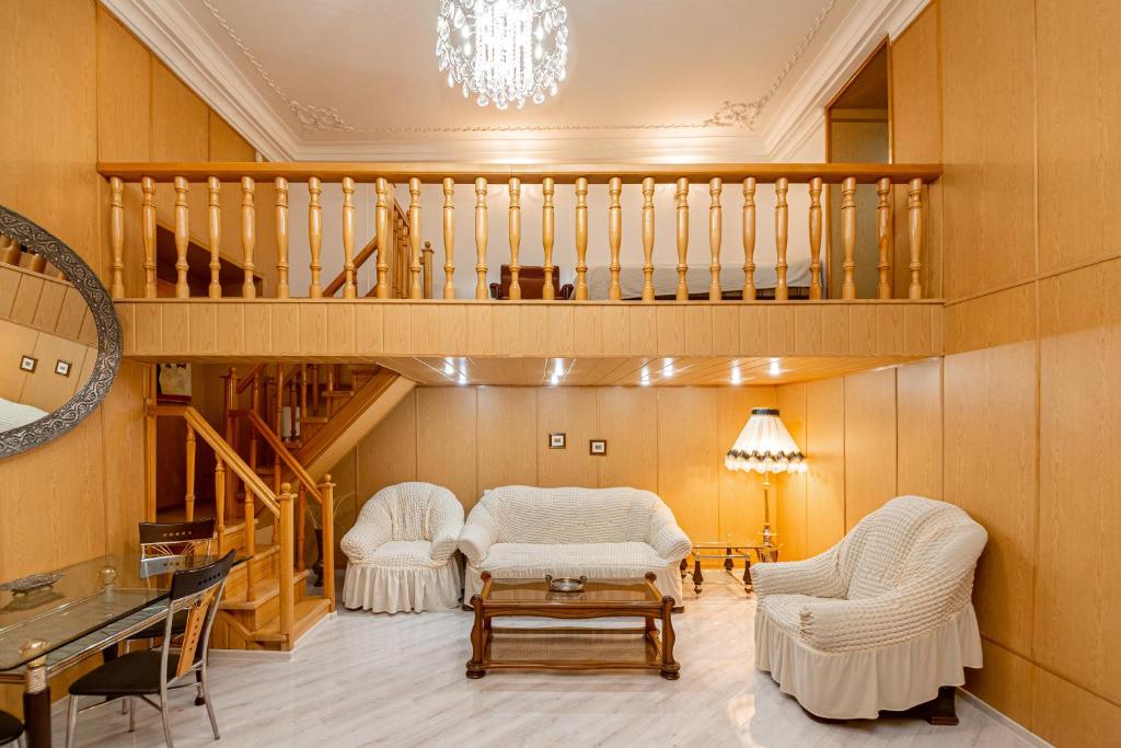 sala de estar con 2 sillas y escalera en Rustaveli Downtown ApartHotel, en Tiflis