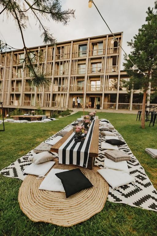 a table in front of a large building with pillows at Hotel Bohinj in Bohinj