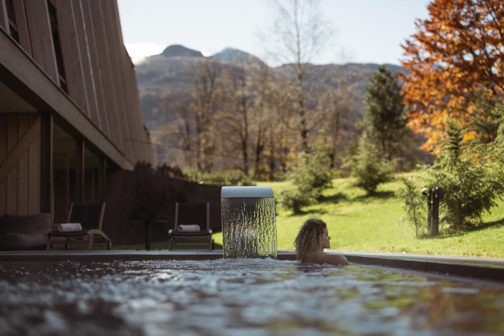 a woman in a bathtub with aperature at Hotel Bohinj in Bohinj