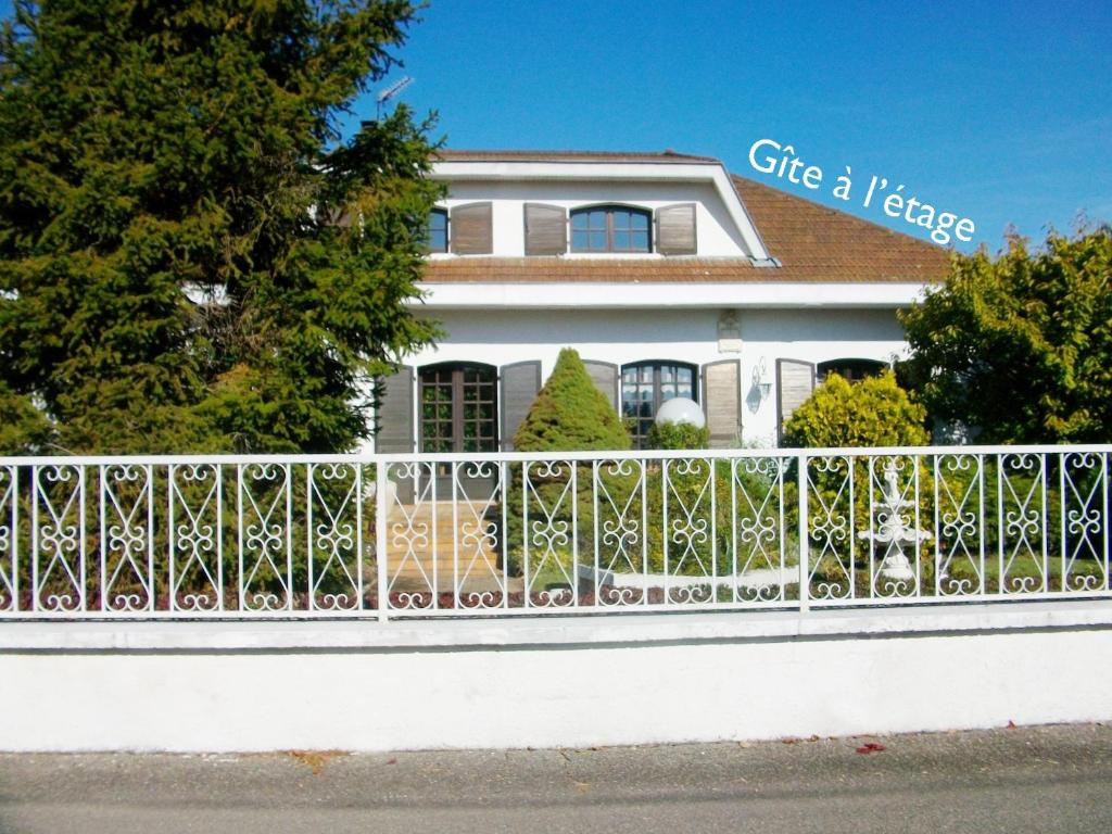 a white house behind a white fence at Les Roses de Rita in Boisset-lès-Montrond