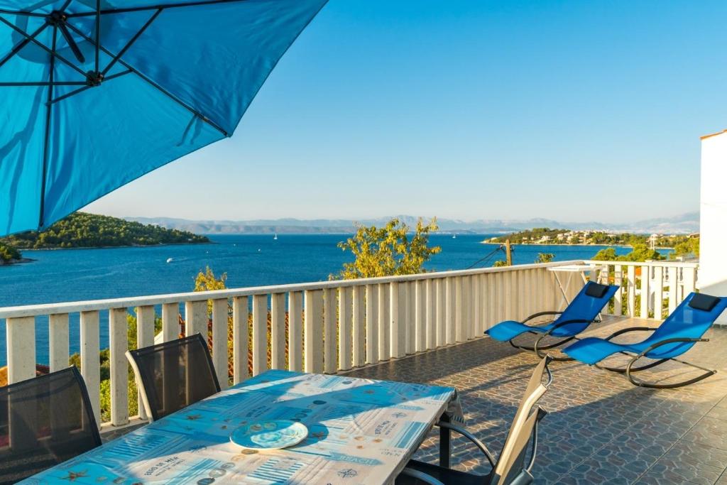 a patio with a table and chairs and an umbrella at Apartment Angie - terrace with sea view in Nečujam
