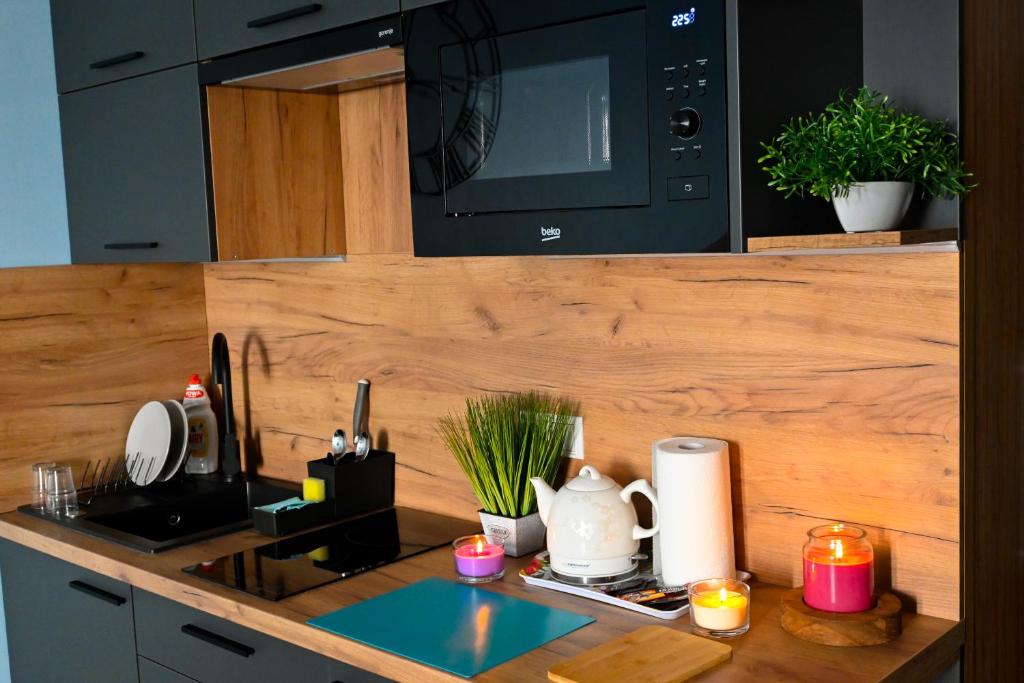 a kitchen with a counter top with a microwave at ApartHotel Legnica - apartamenty z aneksem kuchennym in Legnica