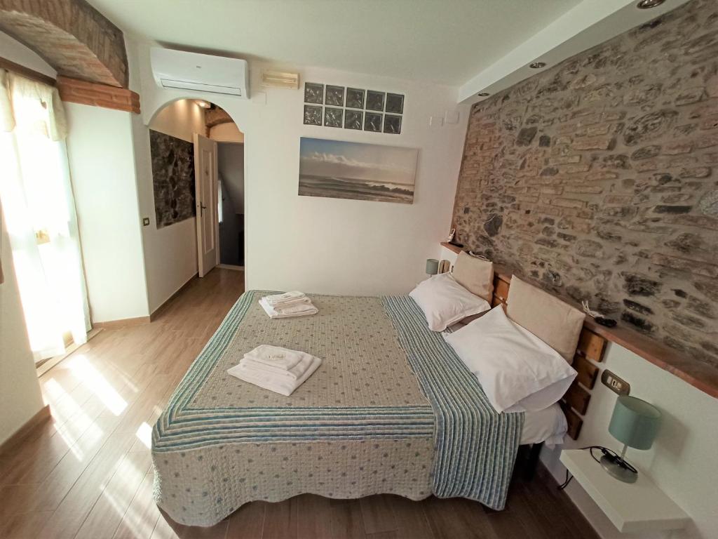 a bedroom with a bed and a brick wall at Affittacamere Albarola in Riomaggiore