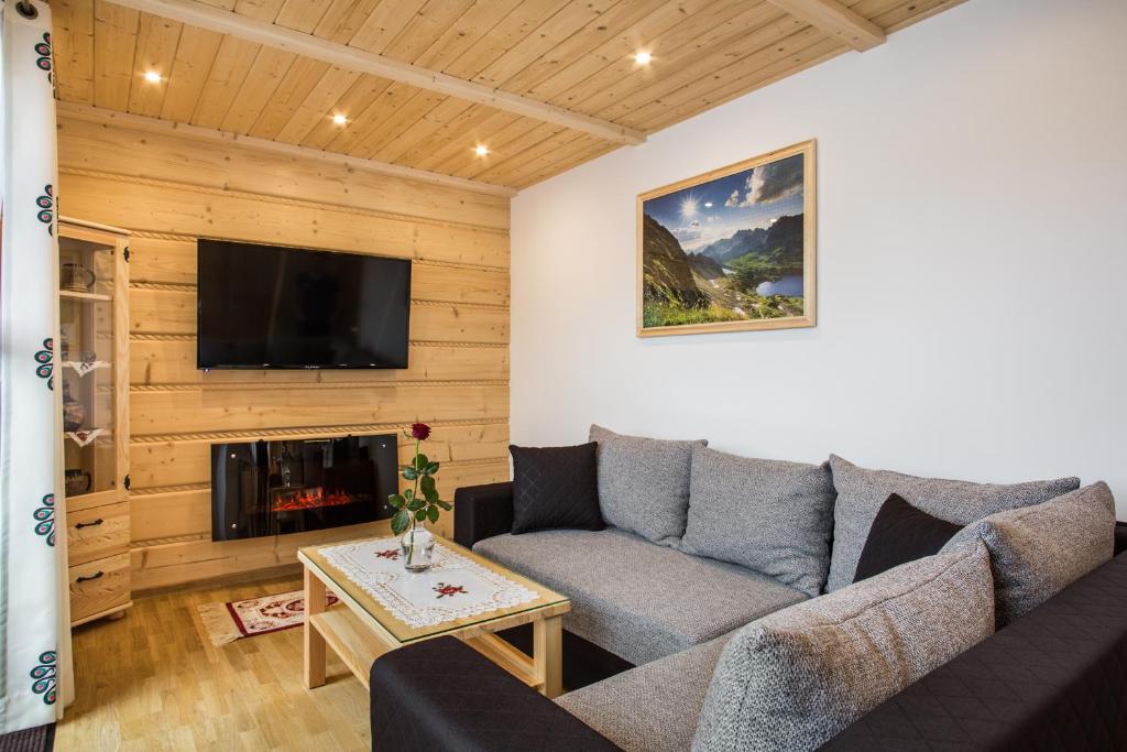 a living room with a couch and a tv at ApartHost Tatra Panorama in Zakopane