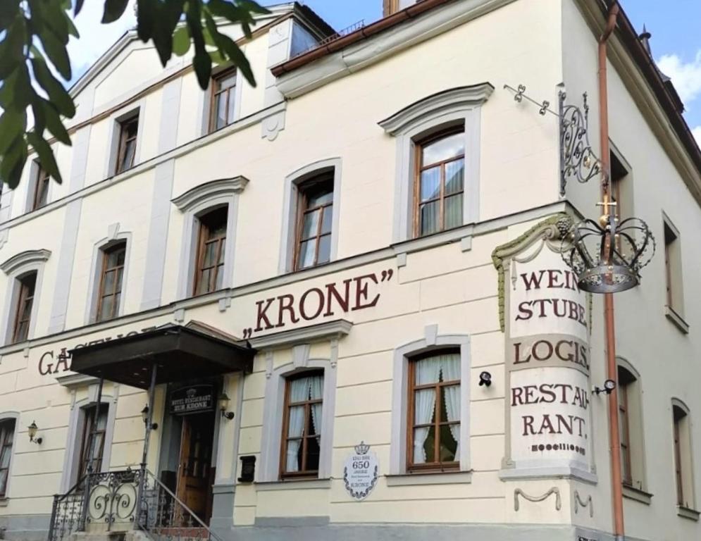 Un bâtiment blanc avec un panneau. dans l'établissement Hotel-Restaurant-Krone, à Bad Brückenau