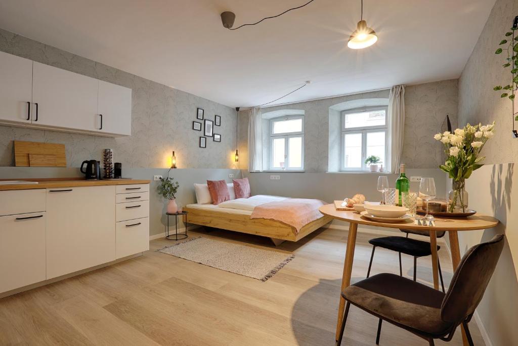 cocina y sala de estar con cama y mesa en Julius Apartments - Iphofen - by homekeepers, en Iphofen