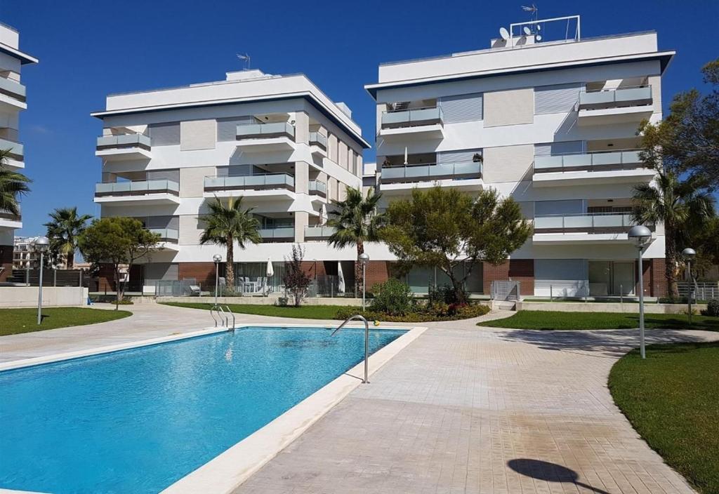 un edificio de apartamentos con piscina frente a un edificio en Villa Martin, en Villamartin