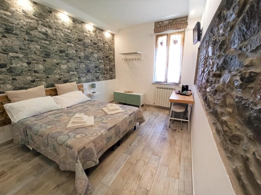 a bedroom with a bed and a stone wall at Affittacamere Albarola in Riomaggiore