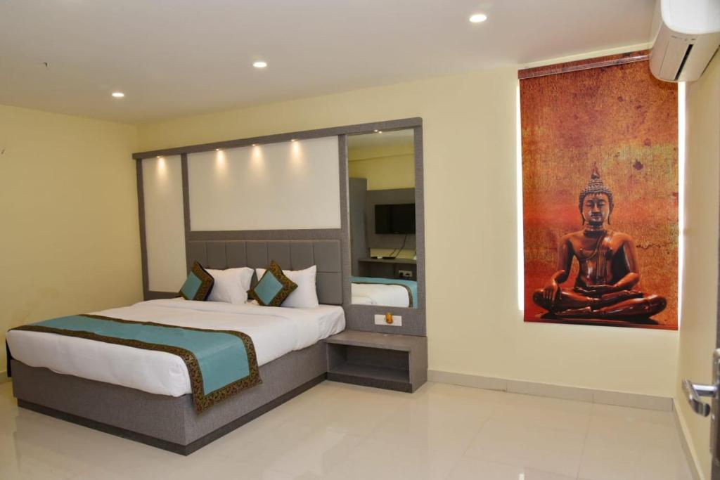 a bedroom with a bed and a painting on the wall at HOTEL TRIDEV GRAND in Varanasi