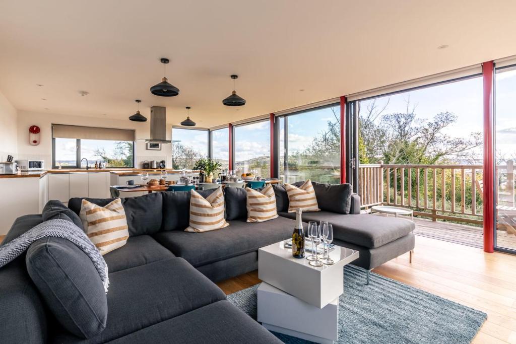 a living room with a couch and a kitchen at Stunning 5 Bedroom Home with Garden & Panoramic Views! in Bath