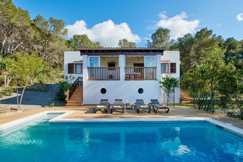 a villa with a swimming pool and a house at Casa para familias en Ibiza in San Antonio Bay