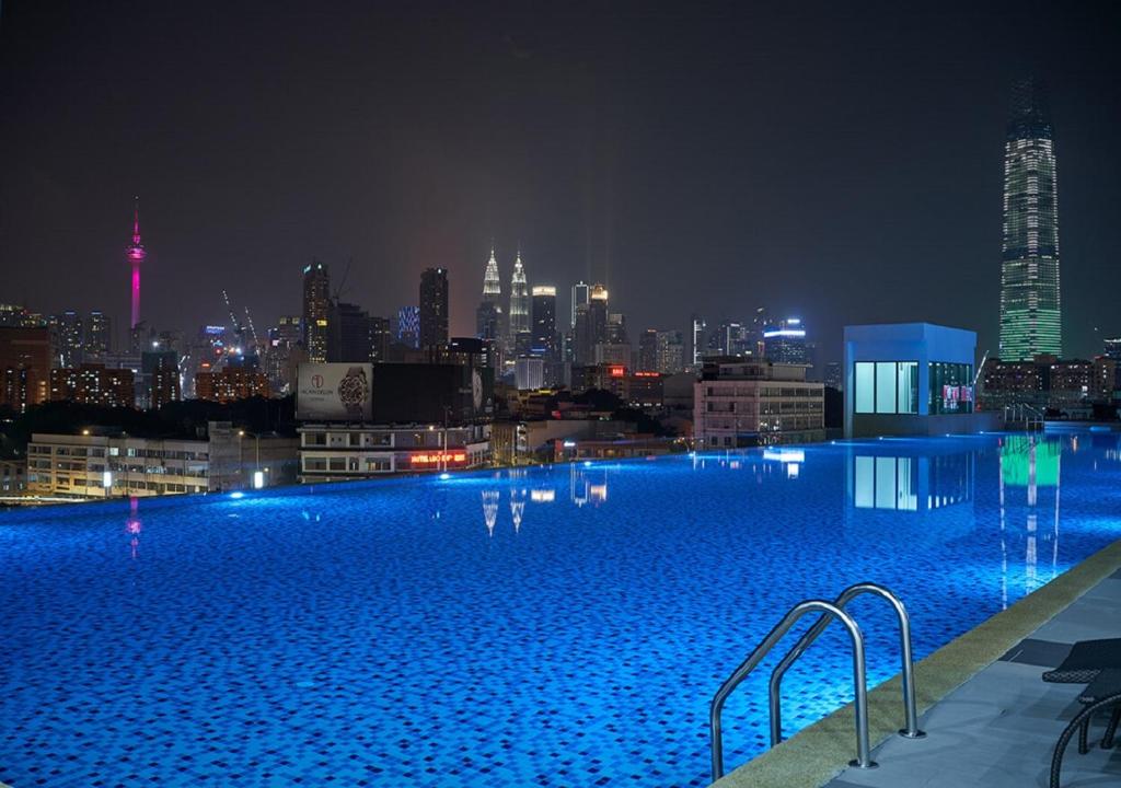 a large swimming pool with a city skyline at night at KL One Residence by Nest Home [Infinity Pool & KL Skyline] in Kuala Lumpur