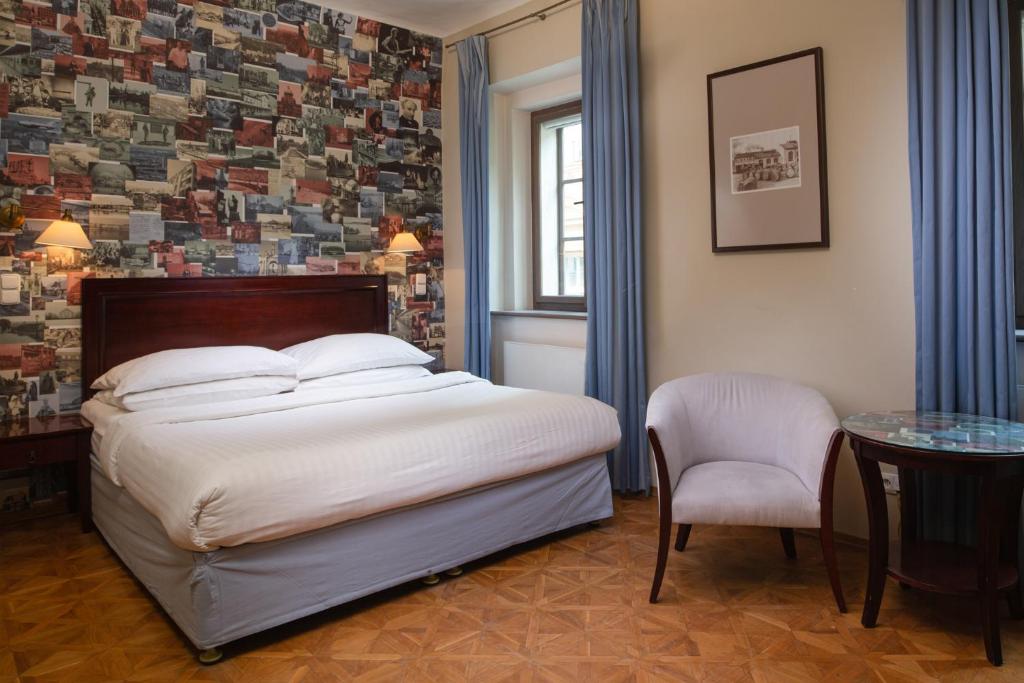 een slaapkamer met een bed, een tafel en een stoel bij Charles Bridge Rooms & Suites by SIVEK HOTELS in Praag